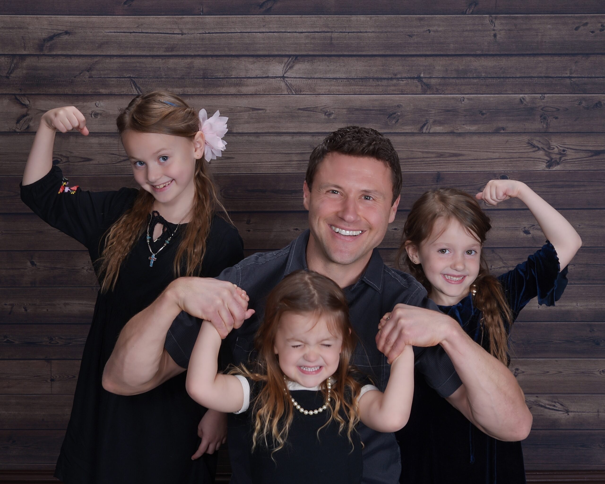 JC Cross with his three daughters flexing